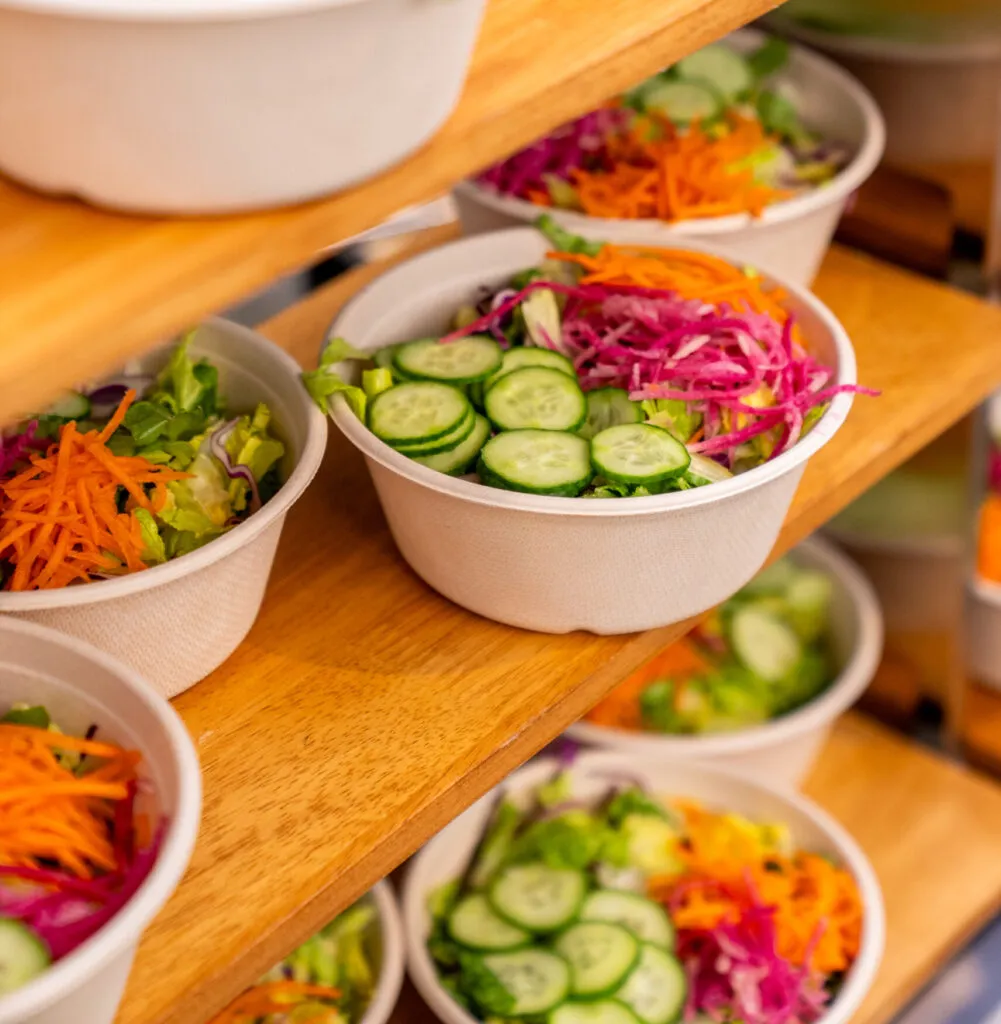 Tiers of salads in compostable bowls