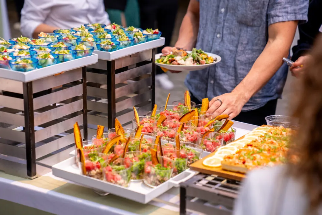 Person taking bowl of food off tray.