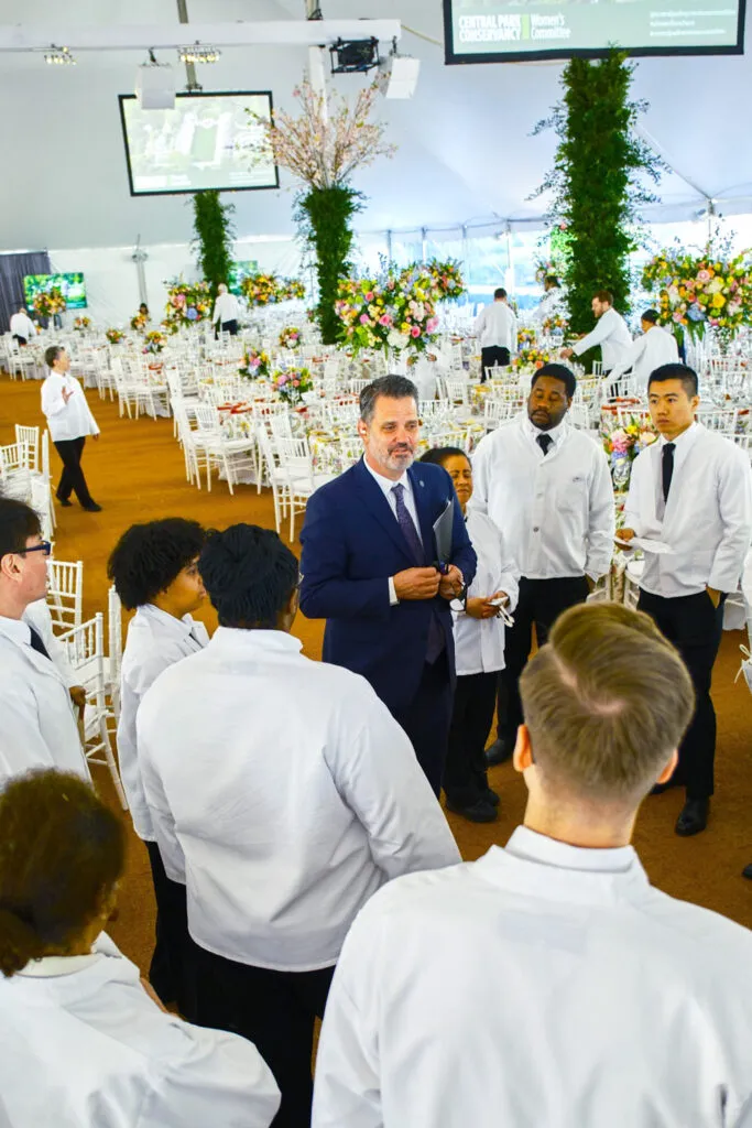 Event captain meeting with service team under event tent.